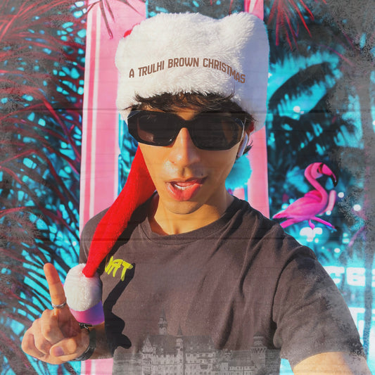 Person wearing a festive hat with text and sunglasses, against a colorful abstract background.